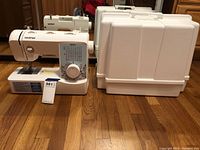 Side view of Brother sewing machine model XR3774 with white hard plastic carrier cover to the right, displaying entire lot contents.