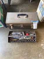 Open Craftsman metal tool box showing the interior removable tray loaded with various sockets, ratchet handles, screwdrivers, a hammer, and other tools.