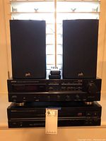 Front view showing Denon amplifier and 5-disc player stacked with Polk speakers on top