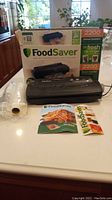 Packed FoodSaver 2200 Series vacuum sealer with box, manual, and rolls on counter