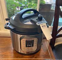 Full side angle of Instant Pot showing power cord and physical condition of appliance.