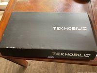 Closed black box labeled TEKNOBILI on top and side