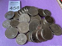 Image showing mixed Canadian one dollar and fifty cent coins on a purple background.