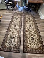 Two rectangular hall runners and one half circle rug arranged on floor for scale and design display