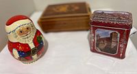Photo showing Russian Santa doll, German tin trinket box, and Italian wooden music box in background