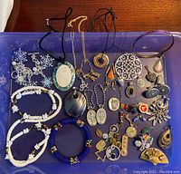 Photo showing the collection of jewelry including bracelets, necklaces, pins, keychains, and earrings on a purple tray.
