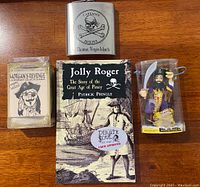 Full lot with flask, book, game deck, and figurine shown together on wooden surface