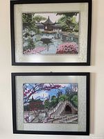 Both framed silk embroidery artworks displayed vertically on a wall with dark frames and fabric matting.