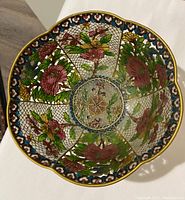 Top-down view revealing the scalloped edge and colorful floral cloisonné panels alternating with openwork lace pattern.