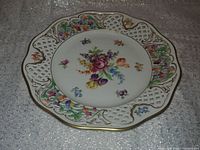 Top-down view of the Dresden floral porcelain plate showing the colorful floral bouquet center and the lattice reticulated rim with gold trim.