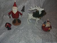 All four Christmas holiday decorations arranged together on a sparkly silver backdrop showing all items included in the lot