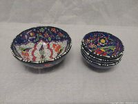 Overall front view of the set showing the four hand-painted mosaic bowls, one large and three smaller stacked.