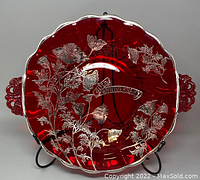 Top-down view of the ruby red glass platter on stand showing silver floral overlay and '40th Anniversary' banner on platter surface.