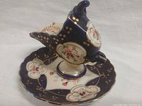 Fine bone china creamer set on saucer, showing floral and gold accents