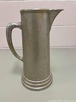 Front and side view showing the vast cylindrical body, handle, and pouring spout of the large Wilton stein-style pitcher