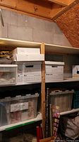 Photo showing shelves with multiple labeled boxes and plastic storage totes containing giftwrapping supplies such as tissue paper and wrapping materials