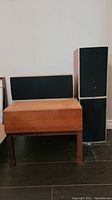 Photo showing teak stereo table with drawer and three Wharfedale Diamond speakers: two standing vertically and one horizontal on top.