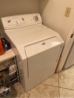 Front view of white dryer showing door and top control panel