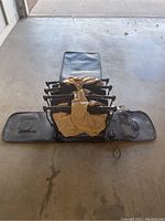 Front view of the folded retractable air bed with visible black frame and tan mattress material packed inside the black casing.