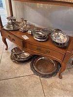 Wide shot of entire assortment on wooden table showing platters, dishes and candlesticks