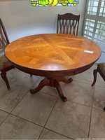 Full view of the round wooden table with chairs around it, showing size and finish.