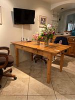Wood table from the side showing two pull-out drawers and natural wood grain finish.