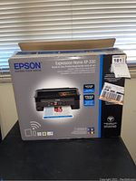 Front view of the EPSON Expression Home XP-330 printer box showing the product image and key features.