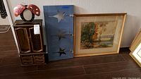 Photo of the jewelry box, blue wall rack, and framed landscape art grouped together on the floor.