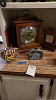 Four pieces on countertop: Seth Thomas mantel clock, smaller four-sided clock, modern triangular clock, and agate stone paperweight