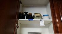 Glassware and plates seen in a cupboard shelf showing the lot arrangement.