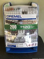 Photo of Dremel All Purpose Accessory Kit sealed in original packaging showing the assortment of 200 pieces including sanding drums, grinding stones, cut-off wheels, polishing wheels, and more.