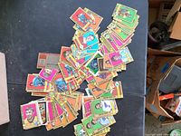 Photo showing a scattered assortment of vintage 1970s hockey cards from various NHL teams on a table, highlighting colorful player cards.
