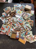 Overview of loose 1970s baseball cards spread on black surface