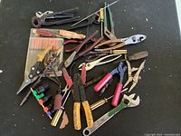 Overview photo showing a large assortment of various hand tools including pliers, wrenches, scissors, small screwdrivers, wire cutters and pipe wrench.