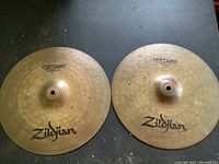 Photo showing two 14-inch Zildjian ZBT Plus cymbals with signs of wear and surface markings.