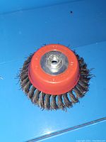 Side view of the 7 inch coarse wire wheel head showing twisted wire bristles and red mounting hub.