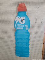 Front view of corrugated retail display sign shaped like a Gatorade Frost sports drink bottle with blue body and red cap, featuring product branding and nutritional labeling.