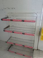 White metal display rack with four wire shelves for chips, shown from front, with decorative tape on shelves.
