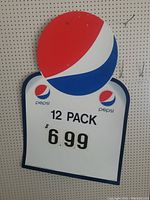Front view of the Pepsi corrugated sign with large Pepsi globe and price advertising 12 pack for $6.99.