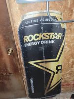 Front view of corrugated Rockstar Energy Drink sign showing wear and scratches