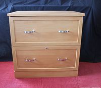 Front view of a two drawer wooden filing cabinet with metal handles