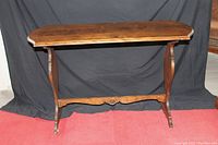 Full view of the antique wooden hall table showing its design, legs, and stretcher