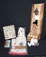 Full lot view showing boxed boiled egg cup pails, chicken napkins, chicken oven mitt, small chicken paper napkins pack, teapot nightlight, and wooden Texas beer cap opener/holder.