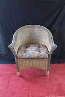Front view of wicker armchair with visible seat cushion and woven pattern