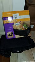 Image displaying the cargo tote with the product box showing the tote filled with groceries and storage items to illustrate use case and product ability.