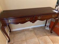 Full view of the Craftline wooden console table showing two drawers, scalloped apron, carved wood detail, curved legs, and dark polished finish.