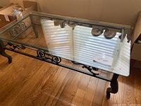 Coffee table top view showing bevelled glass top and iron frame design.