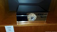 Closed view of the mirrored jewelry box showing the reflective surfaces and large decorative crystal knob on front.