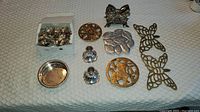Overview of the napkin rings, candleholders, hotplates, and small dish on a table.
