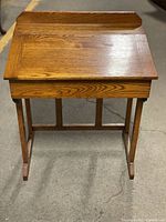 Front view of a wooden children's desk with hinged top closed